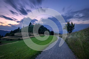 Rural road and chapel on the mountain peak at twilight