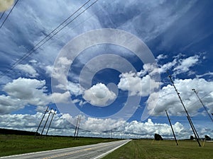 A rural road in the country and beautiful clouds and blue sky