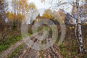 A rural road leading to a ruined ancient temple on an autumn cloudy day