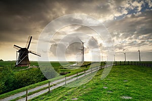 Rural road by old and modern windmills