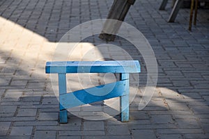 Rural scene, handmade small outdoor bench, wood stool, painted with blue paint