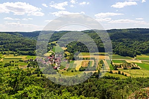 Rural scene with hill panorama, meadows, forest, houses of village Oberzaunsbach in Franconian Switzerland, Germany