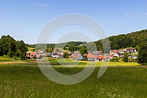 Rural scene with hill panorama, meadows and houses of village Bärnfels near Obertrubach in Franconian Switzerland, Germany