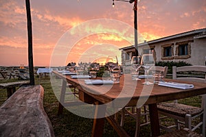 Dining outdoor in Italy. Decked table al fresco by sunset photo