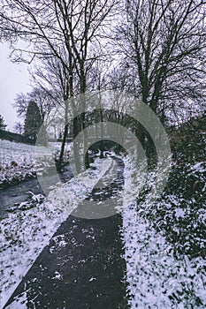 Stream surrounded by trees and roads covered in snow during storm Emma.