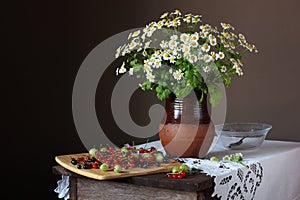 Rural still life with a bouquet of daisies and garden berries.