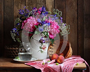 Rural still life with a bouquet of flowers and fruit.