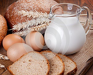 Rural still life. Bread, milk and eggs on the board