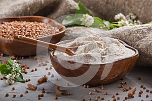 Rural still-life - the buckwheat flour and the peeled groats of buckwheat with blooming branch buckwheat