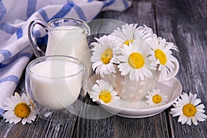 Rural still life. milk in a glass and chamomile on an old board