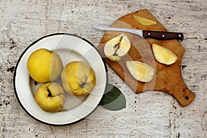 Rural still life ripe yellow quince fruits on the plate and cut