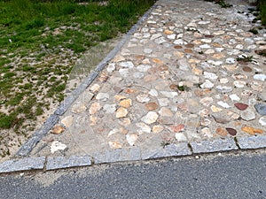 rural stone paving urban square made of quartz cobbles size about 15cm joints filled with gravel brown beige white yellow color