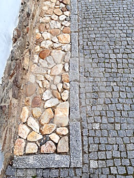 rural stone paving urban square made of quartz cobbles size about 15cm joints filled with gravel brown beige white yellow color