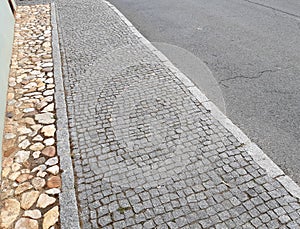 rural stone paving urban square made of quartz cobbles size about 15cm joints filled with gravel brown beige white yellow color