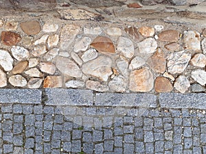 Rural stone paving urban square made of quartz cobbles size about 15cm joints filled with gravel brown beige white yellow color