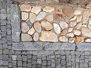 Rural stone paving urban square made of quartz cobbles size about 15cm joints filled with gravel brown beige white yellow color