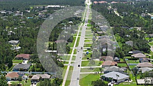 Rural street traffic with driving cars in Florida small town. American suburban landscape with private homes in quiet