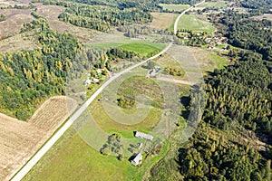 Rural summer landscape in sunny day with countryside road, green fields and forests