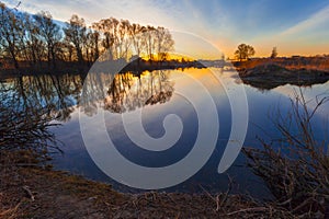 Rural summer sunrise landscape with river and dramatic colorful sky