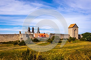 Rural summer view of an ancient medieval brick tower and defense wall surrounding the city of Visby Gotland, Sweden.