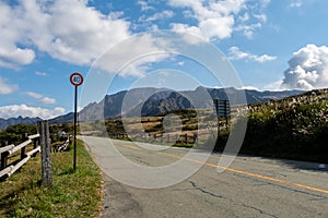 Rural tarmac road with speed limit sign through Aso-Kuju National Park on Kyushu Island, Japan.