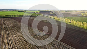 Rural Tractor Plows Fertile Agricultural Land With Plow Against Of Sunset