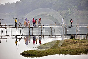 Rural villagers crossing a bamboo bridge at bardhaman west bengal india