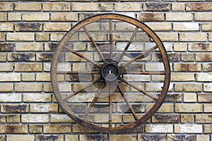 Rural wagon wheel on a brick wall