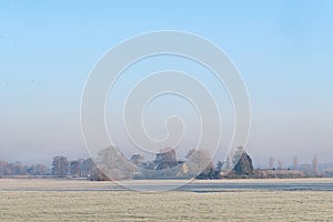 Rural winter landscape with frozen meadow