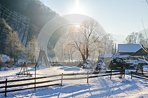 Rural winter view of a Romanian Village next to the woods with a wooden fence and a lot of snow