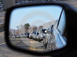 Rush hour traffic jam as viewed from a cars side view mirror