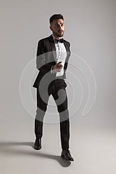 Rushed elegant man in tuxedo fast marching photo