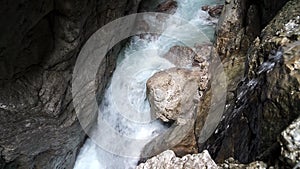 Rushing foaming fast flowing water between the rocks in a narrow gorge