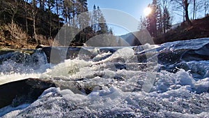 Rushing River over Rocks in Forest with Mountains