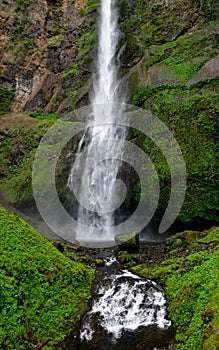 rushing water fall along a moss covered cliff photo