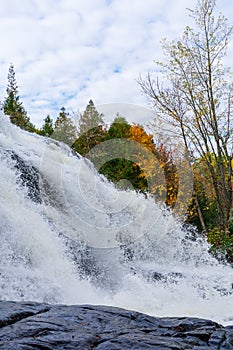 Waterfall rushing over rocks in autumn