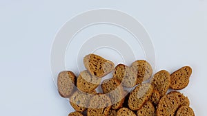 Rusks of dark wheat bread spinning in a circle on a white background. The concept of healthy gluten-free food