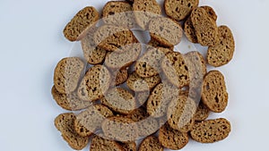 Rusks of dark wheat bread spinning in a circle on a white background. The concept of healthy gluten-free food