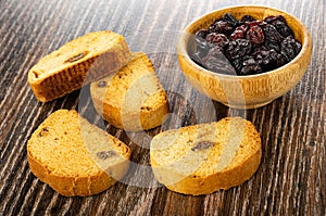 Rusks with raisin, dried grape in bowl on wooden table