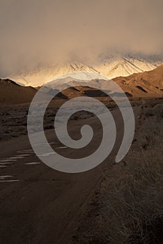 Russet color hills and snowy mountain shrouded in clouds