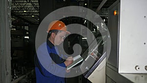 RUSSIA, ANGARSK - JUNE 8, 2018: Operator monitors control panel of production line. Manufacture of plastic water pipes