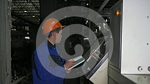 RUSSIA, ANGARSK - JUNE 8, 2018: Operator monitors control panel of production line. Manufacture of plastic water pipes