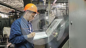RUSSIA, ANGARSK - JUNE 8, 2018: Operator monitors control panel of production line. Manufacture of plastic water pipes