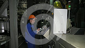 RUSSIA, ANGARSK - JUNE 8, 2018: Operator monitors control panel of production line. Manufacture of plastic water pipes