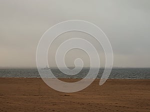 Russia, Arkhangelsk, Northern Dvina river - sandy beach and tug boat at autumn day