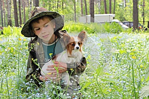 Russia,  a boy with a decorative dog in his arms in flowers, a child and a pet are friends