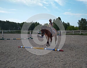 Russia,  a child boy riding a horse in the arena athlete in a helmet