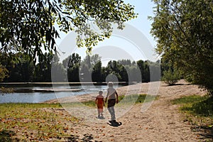 Russia, children play on the beach by the river in summer landscape in the park