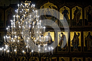 Russia, city of Magnitogorsk, - January, 7, 2019. Tiered chandelier in the night temple on the background of Orthodox icons