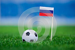 Russia Flag and football ball on green grass. Photo, copy space